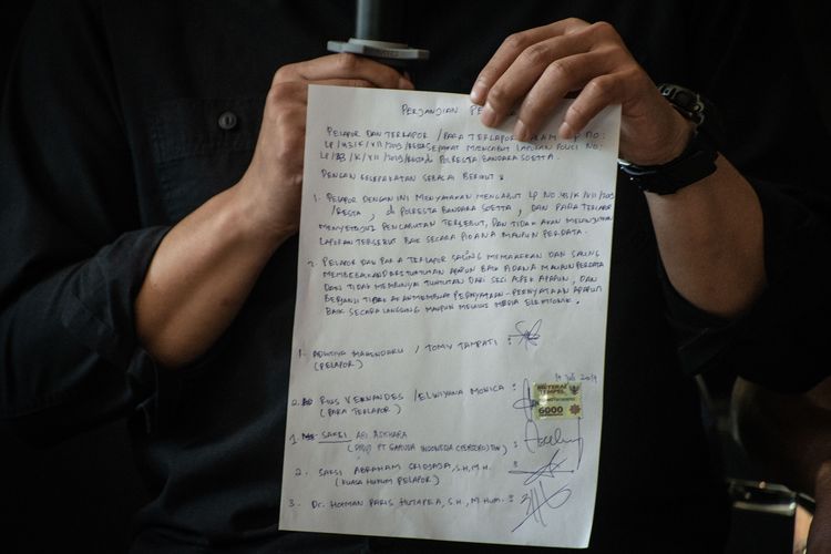 Dirut Garuda Indonesia Ari Askhara menunjukkan surat perjanjian damai antara Serikat Karyawan Garuda Indonesia (Sekarga) dengan Youtuber Rius Vernandes dalam konferensi pers di Jakarta, Jumat (19/7/2019). Selain berdamai, Sekarga juga mencabut laporan polisi yang sebelumnya dibuat atas unggahan Rius soal kartu menu bertulisan tangan di kabin pesawat Garuda Indonesia. 
