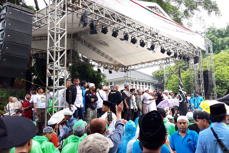 Massa di depan Rumah Prabowo lakukan doa bersama dan bacakan shalawat di bawah guyuran hujan, Jumat (19/4/2019).
