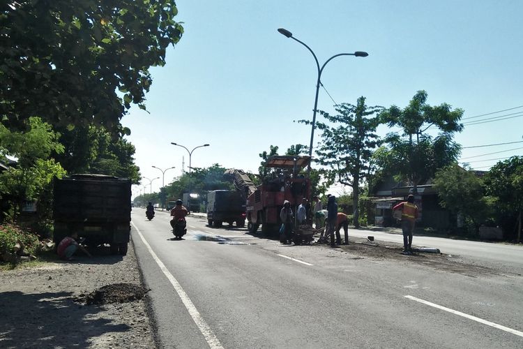 Salah satu ruas jalan raya di jalur pantura dekat perbatasan Gresik-Lamongan, terlihat terus diperbaiki oleh petugas.