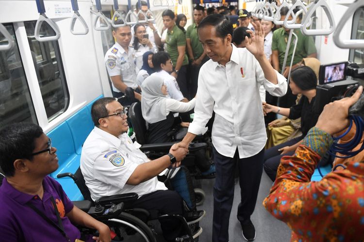 Presiden Joko Widodo (Jokowi) bersalaman dengan penyandang disabilitas saat mencoba menggunakan moda transportasi MRT, di Jakarta. 