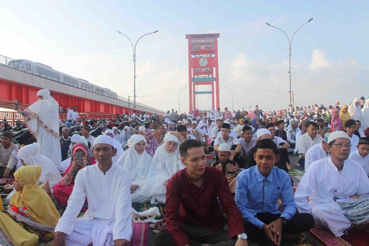 Para jemaah shalat Idul Fitri memenuhi jembatan Ampera Palembang, Sumatera Selatan, Rabu (5/6/2019).
