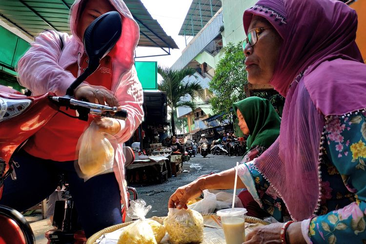 Bu Rini (kanan) menjual toge terakhirnya kepada pembeli di Pasar Palmerah, Jakarta Barat pada Kamis (11/7/2019).