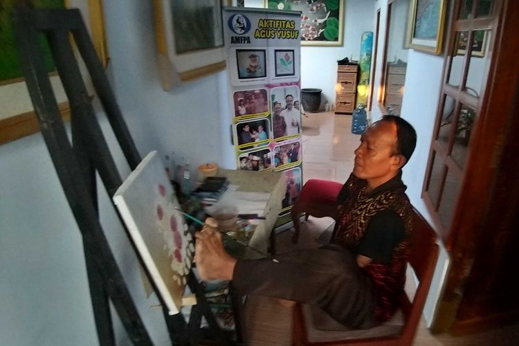 LUKIS KAKI?Tak hanya menggunakan mulut, Agus Yusuf pelukis difabel asal Madiun juga menggunakan sarana kaki kirinya untuk melukis.