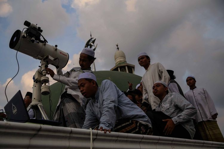 Petugas Lembaga Falakiyah Pondok Pesantren Al-Hidayah Basmol, Jakarta Barat melakukan pemantauan hilal di atas Masjid Al-Musariin, Minggu (5/5/2019).