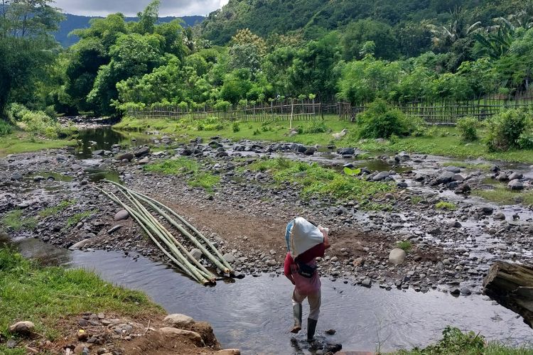 Seorang penambang membawa pembekalan makanan mingguan dari kampung menuju lokasi lubang tambang di atas gunung.