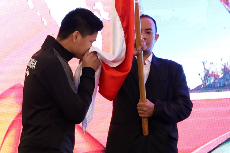 Pebulu tangkis ganda campuran Indonesia, Praveen Jordan, mencium bendera Indonesia saat acara pelepasan menuju Piala Sudirman 2019.