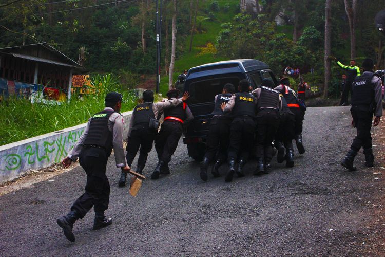  Anggota Kepolisian Resor Magetan yang bertugas sebagai tim pengganjal ban di tiungan dan tanjakan curam di jalyr Telaga Sarangan yang selalu siap membantu pengguna jalan yang kesulitan menanjak.