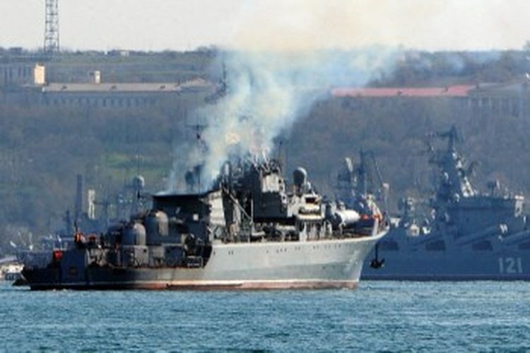 Dalam file foto yang diambil pada tanggal 30 Maret 2014, kapal patroli angkatan laut Rusia 'Pytliviy' (kiri) berlayar di dekat kapal penjelajah rudal andalan Angkatan Laut Rusia 'Moskva' (kanan) yang berlabuh di teluk kota Sevastopol di Crimea. Moskva, kapal perang Rusia di Laut Hitam, rusak parah oleh ledakan amunisi, kata media pemerintah Rusia pada 14 April 2022.