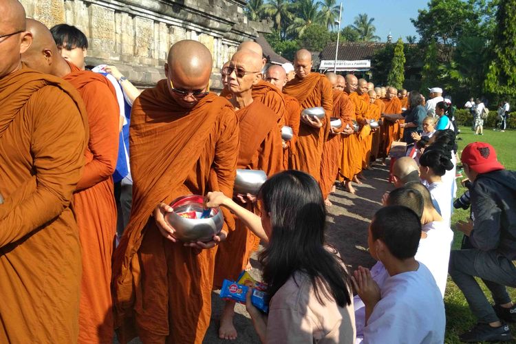 Para biksu sedang menerima derma dari umat dalam prosesi Pindapata di Candu Menndut Magelang, Sabtu (18/5/2019).