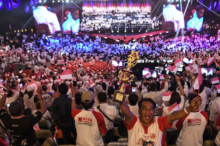 Pendukung mengibarkan Bendera Merah Putih saat menanti Presiden terpilih Joko Widodo menyampaikan pidato pada Visi Indonesia di Sentul International Convention Center, Bogor, Jawa Barat, Minggu (14/7/2019).