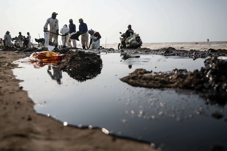 Warga mengumpulkan limbah tumpahan minyak milik Pertamina di Pesisir Pantai Cemarajaya, Karawang, Jawa Barat, Minggu (4/8/2019). Pasir yang tercemar minyak tersebut dikumpulkan dan dipindahkan ke pabrik penyimpanan limbah untuk dimusnahkan.