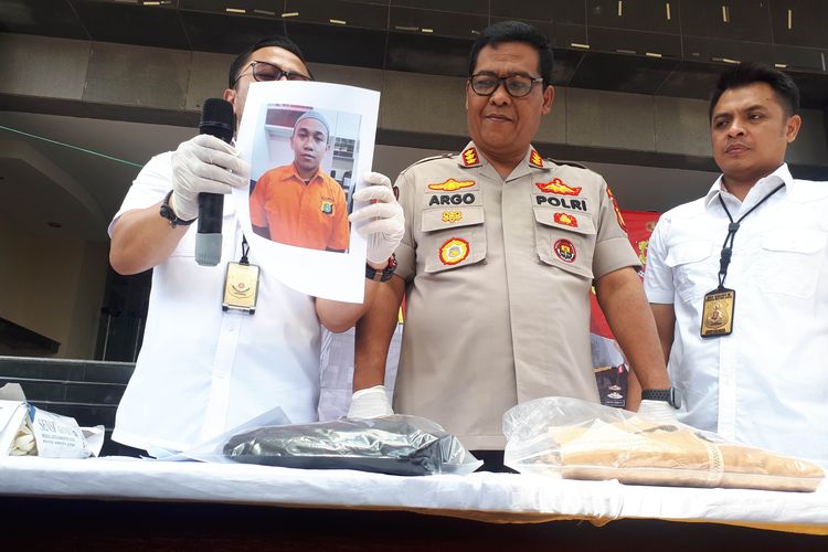 Polisi menampilkan foto tersangka yang mengancam memenggal kepala Presiden Joko Widodo berinisial HS (25) di Polda Metro Jaya, Senin (13/5/2019).