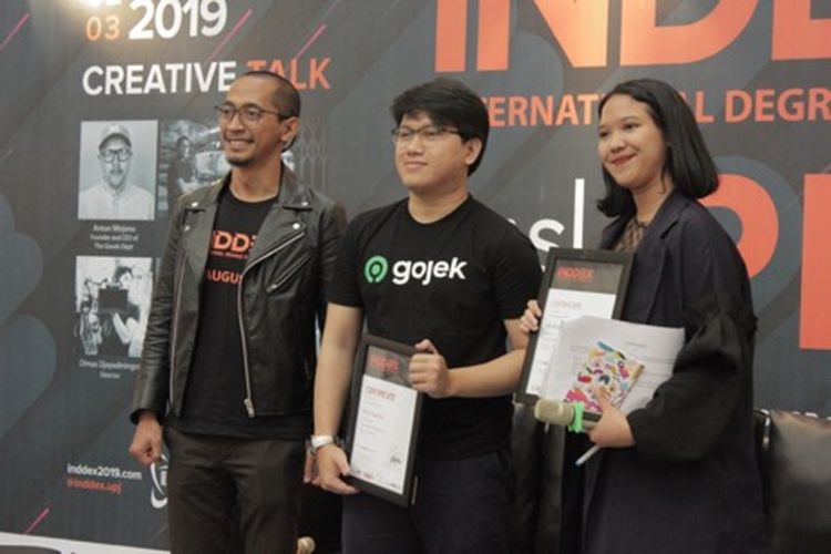 Pemberian Piagam Penghargaan pada Devi Nugraha selaku Corporate Communication Gojek dan Berliana Sinaga selaku moderator oleh Fitorio Bowo Leksono selaku Ketua Acara INDDEX 2019 dalam Creative Talk ?Career In Creative Industry? (3/8/2019).