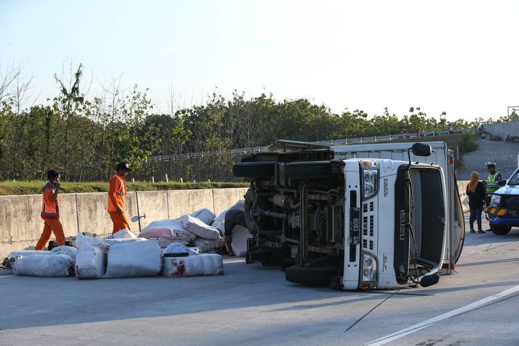 Truk terguling karena mengalami kecelakaan di ruas tol Solo - Ngawi kilometer 555, Ngawi, Jawa Timur, Jumat (24/5/2019). Kecelakaan yang mengakibatkan satu orang luka-luka ini disebabkan pecah ban. 