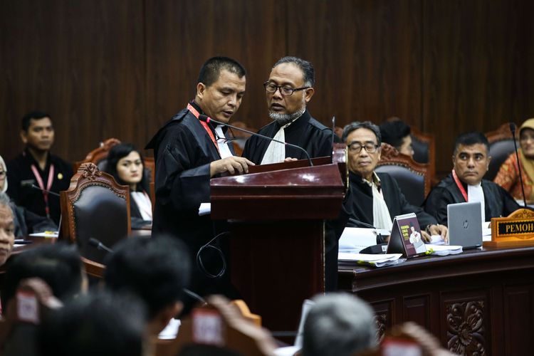 Ketua Tim Hukum pasangan Prabowo Subianto-Sandiaga Uno, Bambang Widjojanto (berdiri-kanan) terlihat berdiskusi dengan anggota tim hukum Denny Indrayana di sidang perdana sengketa pilpres 2019 di Gedung Mahkamah Konstitusi, Jakarta, Jumat (14/6/2019).