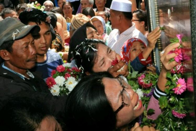 Keluarga korban tabur bunga di monumen kapal tenggelam di Tiga Ras, Kabupaten Simalungun. 
