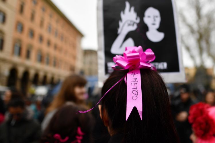 Perempuan mengenakan pita di rambut dengan tulisan #METOO pada aksi damai peringatan Womens Day di Roma, Italia, pada 8 Maret 2018. 