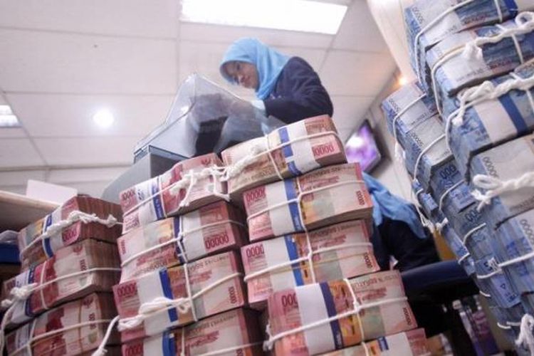 Petugas kasir menghitung uang rupiah yang disetor nasabah di Bank Mandiri kantor cabang pembantu Pertamina Unit Pemasaran III Jakarta,beberapa waktu lalu.