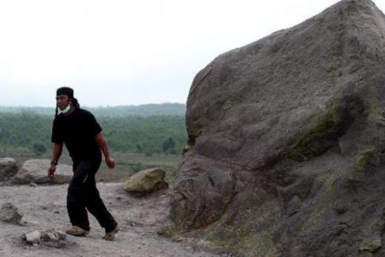 Wisatawan mengunjungi batu alien di tepi Kali Gendol, Cangkringan, Sleman, DI Yogyakarta, saat mengikuti wisata lava tour di kaki Gunung Merapi, Jumat (17/5/2013). Wisata mengunjungi daerah bekas aliran lava erupsi Merapi ini dipungut biaya Rp 300.000 - Rp 500.000 per trip.