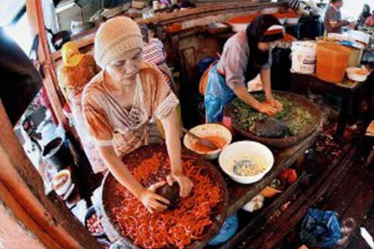 Tiga perempuan menggiling belasan kilogram cabai setiap hari di Pasar Ibuh Timur, Payakumbuh, Sumatera Barat, Rabu (10/7/2013). Hanya dengan cabai yang digiling menggunakan tangan, rendang terlezat bisa dihasilkan. Para koki di Istana Silinduang Bulan, Batusangkar, juga menggunakan cabai giling seperti ini untuk membuat rendang yang akan disajikan kepada sultan, presiden, dan pejabat yang bertandang ke sana.