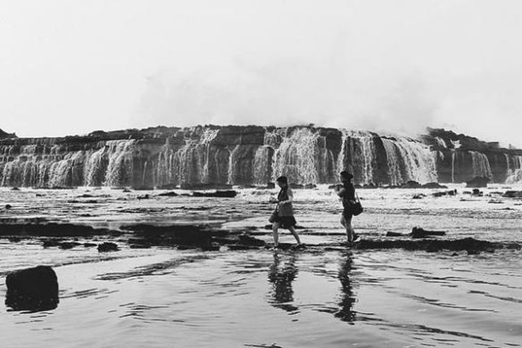 Wisatawan berjalan di sekitar Karang Taraje di Desa Sawarna, Kecamatan Bayah, Kabupaten Lebak, Banten, akhir Mei 2014. Sawarna adalah desa wisata yang memiliki sejumlah tempat wisata menarik, seperti goa, pantai dengan pasir putih, dan tempat berselancar. Warga desa itu juga sudah menjadi masyarakat sadar wisata. 