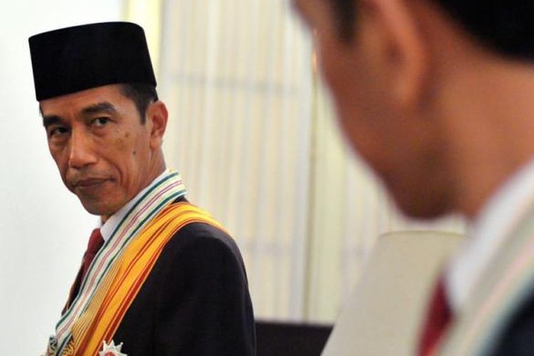 In this handout photograph taken on October 22, 2014 and released by the presidential palace on October 25, 2014, Indonesian President Joko Widodo prepares for an official portrait session at the presidential palace in Jakarta.  Joko Widodo, 53, popularly known by his nickname Jokowi was inaugurated as Indonesias president October 20, capping a remarkable rise from an upbringing in a riverside slum.    AFP PHOTO / SETNEG / CAHYO BRURI SASMITO