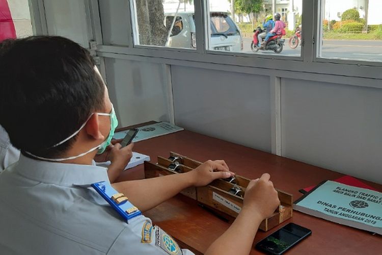 Salah seorang petugas dari Dinas Perhubungan Kabupaten Pekalongan, Jawa Tengah menghitung kendaraan yang melintas di jalur pantura.