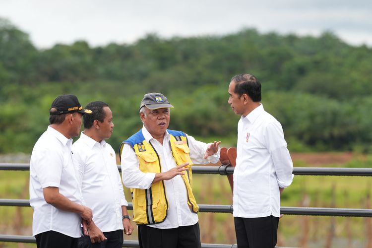 Menteri PUPR Basuki Hadimuljono (tengah, pakai rompi kuning) memberikan penjelasan tentang progres kinerja kementeriannya kepada Presiden Joko Widodo (kanan). Gambar diambil pada 4 Juni 2024.