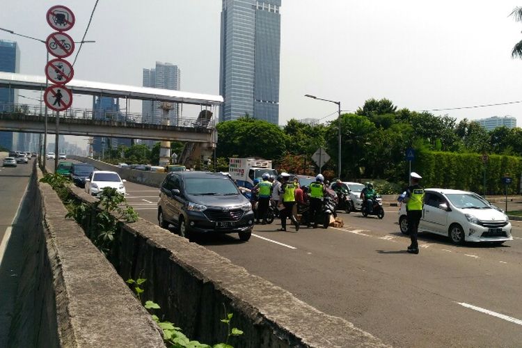 Polisi melakukan penindakan terhadap pengendara motor yang masih nekat melintas di JLNT Casablanca, Selasa (25/7/2017).