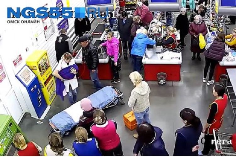Tangkapan layar kamera CCTV di sebuah supermarket di Omsk ini memperlihatkan kasir toko tengah menggendong bayi yang baru saja lahir.