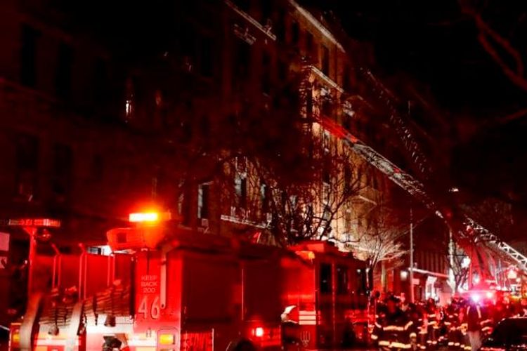 Petugas pemadam kebakaran berupaya memadamkan api pada kebakaran di apartemen, di Bronx, New York, Amerika Serikat, Kamis (28/12/2017). (AP via CNN)