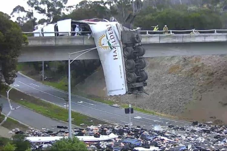 Truk pengangkut produk unggas mengalami kecelakaan di Melbourne, Victoria, sehingga menyebabkan sebagian badan truk bergelantungan di jalan layang, pada Selasa (20/11/2018). (VicRoads via BBC)
