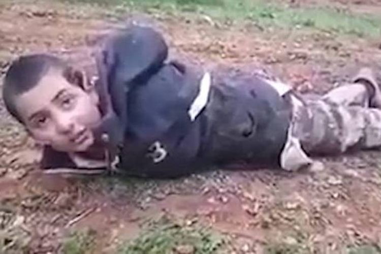 Dalam foto yang diambil dari video ini terlihat seorang bocah laki-laki anggota ISIS tertelungkup di tanah setelah ditangkap anggota pasukan pemberontak Suriah, FSA.