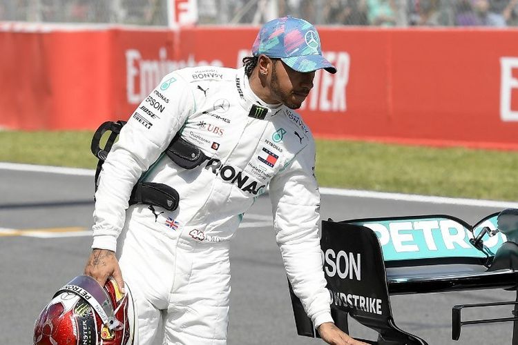 Pebalap Mercedes, Lewis Hamilton, memeriksa ban mobilnya pada sesi kualifikasi GP Spanyol di Sirkuit Catalunya, 11 Mei 2019. 