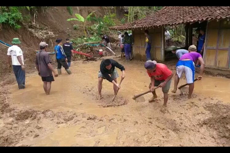 Warga gotong royong mengeluarkan tanah yang menerjang rumah milik Sukiran di Dusun Klendrekan, Rabu (29/11/2018). Warga rekam foto dan video selagi mereka gotong royong di sana.