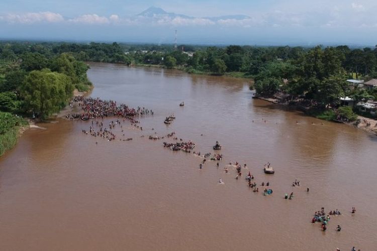 Para migran dari Honduras mencapai Meksiko setelah menyeberangi Sungai Suchiate dari Tecun Uman di Guatemala ke Ciudad Hidalgo di Meksiko, Senin (29/10/2018). (AFP/Carlos Alonzo)