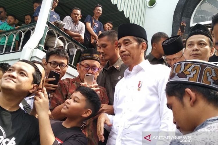 Presiden Joko Widodo memenuhi permintaan swafoto dengan jamaah usai Shalat Jumat di Masjid Syuhada Kota Baru, Yogyakarta, Jumat (7/6). 