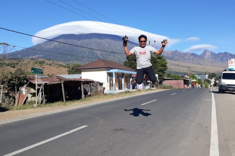 Warga menyaksikan fenomena topi awan yang melingkari puncak hingga lereng Gunung Rinjani, di Lombok, NTB, Rabu (17/7/2019. 