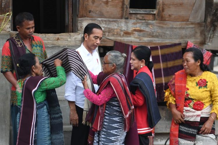 Presiden Joko Widodo (tengah) bersama Ibu Negara Iriana Joko Widodo (kedua kanan) mengenakan kain ulos saat mengunjungi kawasan kerajinan tenun ulos di Presiden tinjau kawasan kerajinan ulos di Pulau Samosir, Danau Toba, Sumatera Utara, Selasa (30/7/2019).