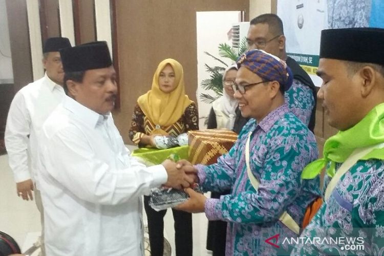 Ketua DPRD Labura Drs H Ali Tambunan didampingi Bupati H Kharuddin Syah SE menyerahkan bumbu pecal secara simbolis kepada TPHD Labura Tuan Sibiobio sebelum pelepasan di aula Ahmad Dewi Syukur Aekkanopan, Jumat (2/8/2019).