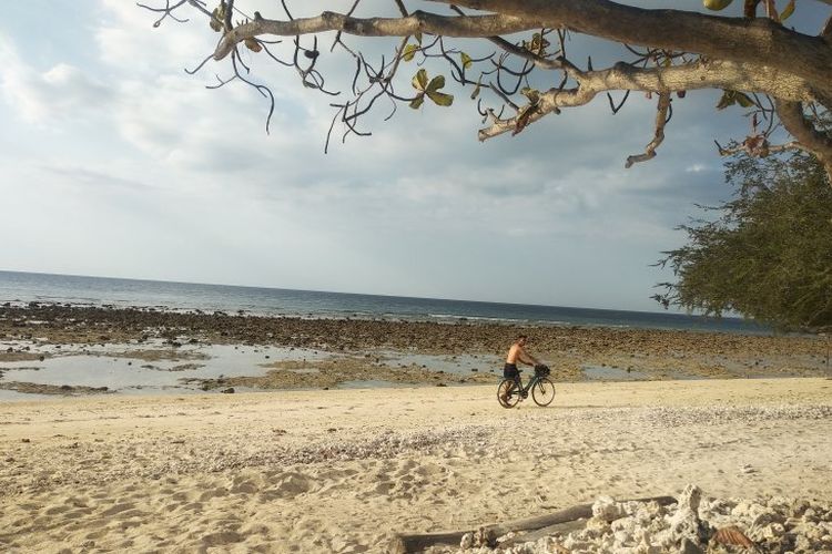 Seorang turis bersepeda di kawasan pantai Gili Trawangan, Lombok Utara, Nusa Tenggara Barat