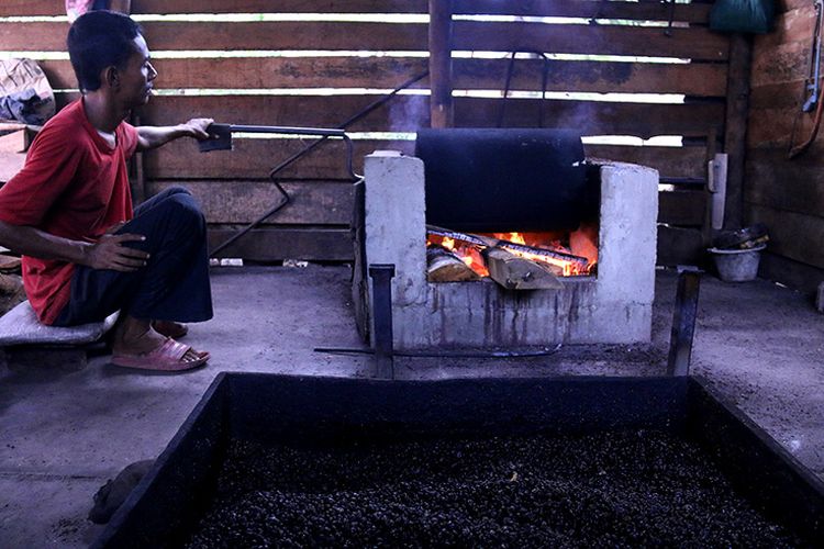 Irwansyah sedang menggonseng biji kopi jenis robusta secara tradisional di tempat usaha yang dirintis oleh kakeknya sejak tahun 1980 di Desa Meunasah Papeun, Lamreung, Aceh Besar.