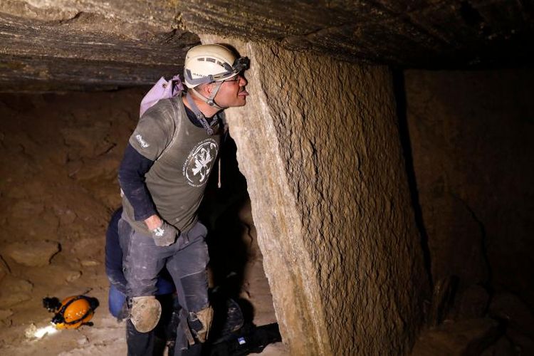 Salah seorang penjelajah mencoba merasakan dinding gua Malham yang merupakan gua garam terpanjang di dunia.