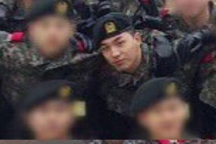 Mengenakan seragam militer, Taeyang tampak berfoto dengan rekan satu baraknya sambil memamerkan senyum manisnya.