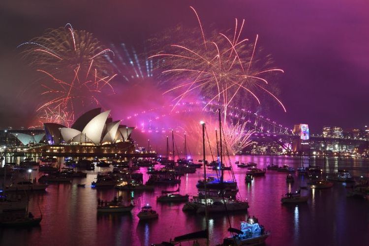 Kembang api Malam Tahun Baru di atas Harbour Bridge dan Opera House selama pertunjukan kembang api sebelum acara tengah malam utama di Sydney, Australia, Minggu (31/12/2018). (AFP/TAMAN PETER)
