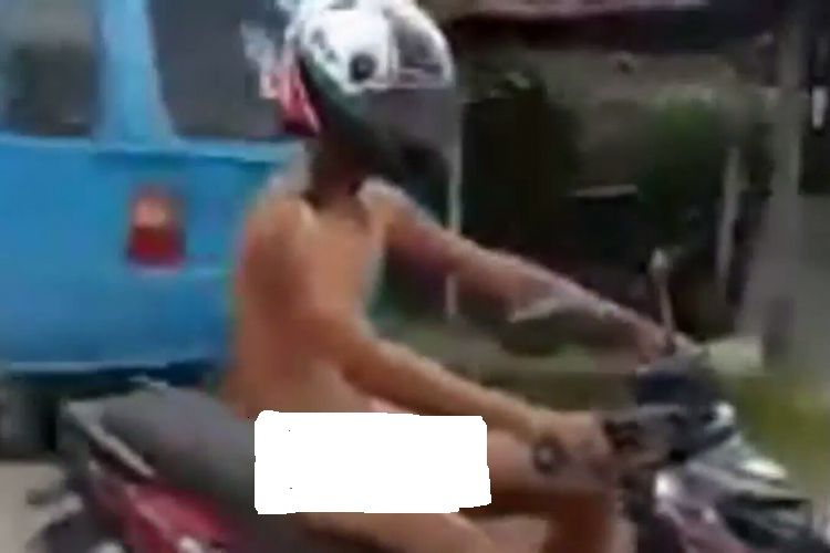 AT (38) seorang pegawai negeri sipil (PNS) tengah mengendarai sepeda motor miliknya tanpa busana. Kamis, (29/7/2017).