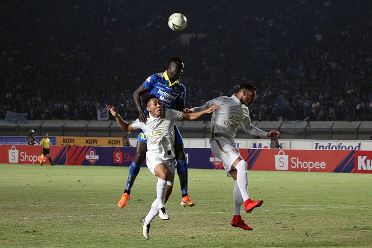 Penyerang Persib Bandung, Ezechiel NDouassel (biru) berduel bersama dua pemain belakang PSS Sleman, saat kedua tim bentrok pada pekan ke-17 Liga 1 2019.