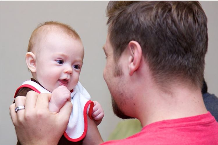 Peserta pelatihan Boot Camp for New Dads sedang memangku dan mengajak anaknya yang masih bayi untuk bercanda.