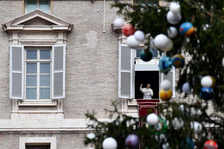 Paus Fransiskus melambaikan tangan kepada umat yang berkumpul di Lapangam Santo Petrus, Vatikan untuk berdoa Malaikat Tuhan di akhir misa suci untuk menandai hari perdamaian dunia pada 1 Januari 2018. (AFP/Vincenzo Pinto).