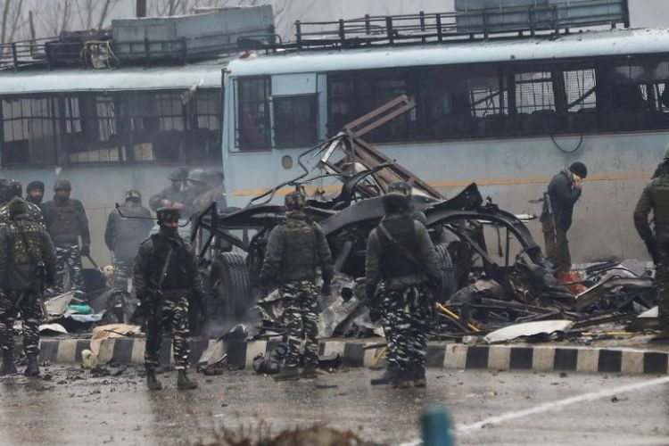 Pasukan keamanan India memeriksa sisa-sisa kendaraan yang hancur diserang bom bunuh diri oleh kelompok pemberontak Pakistan, Jaish-e-Mohammad, di dekat kota Awantipur, Lethpora di Kashmir, Kamis (14/2/2019). (AFP)